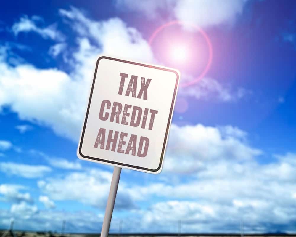 Street sign saying tax credit ahead.