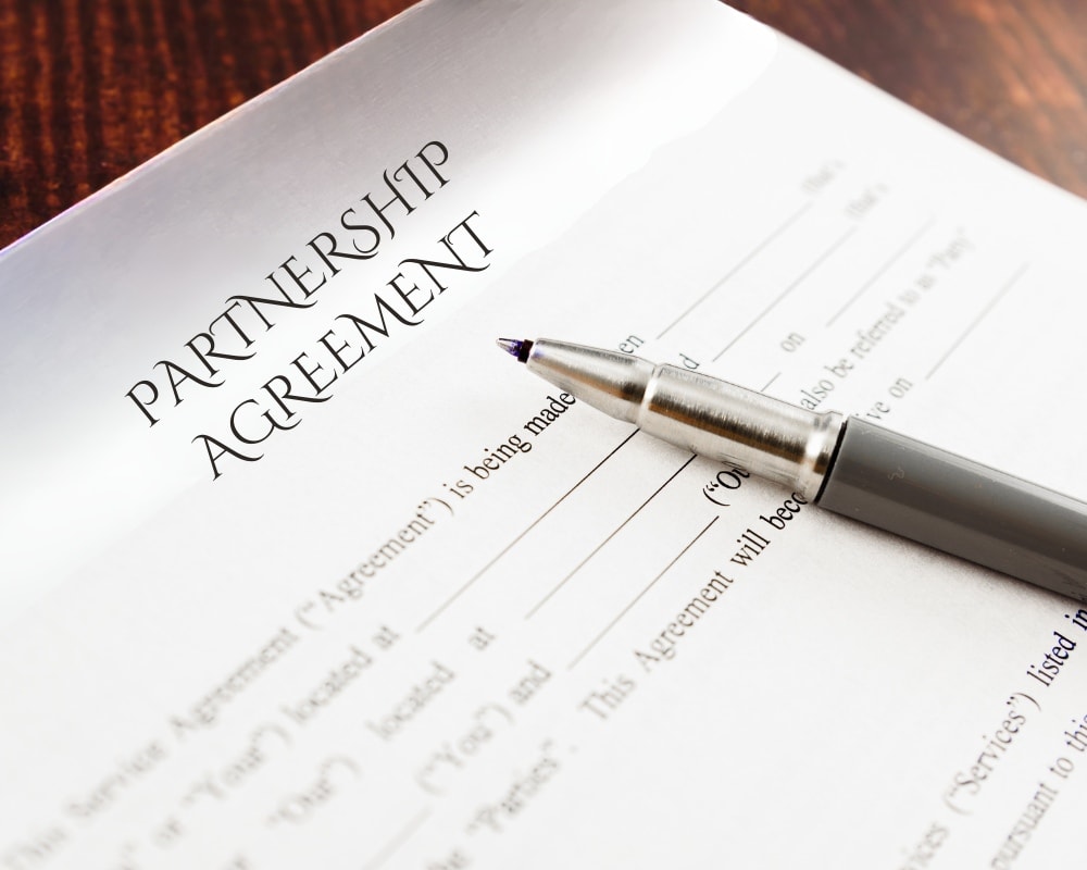 Document titled Partnership Agreement with a pen.