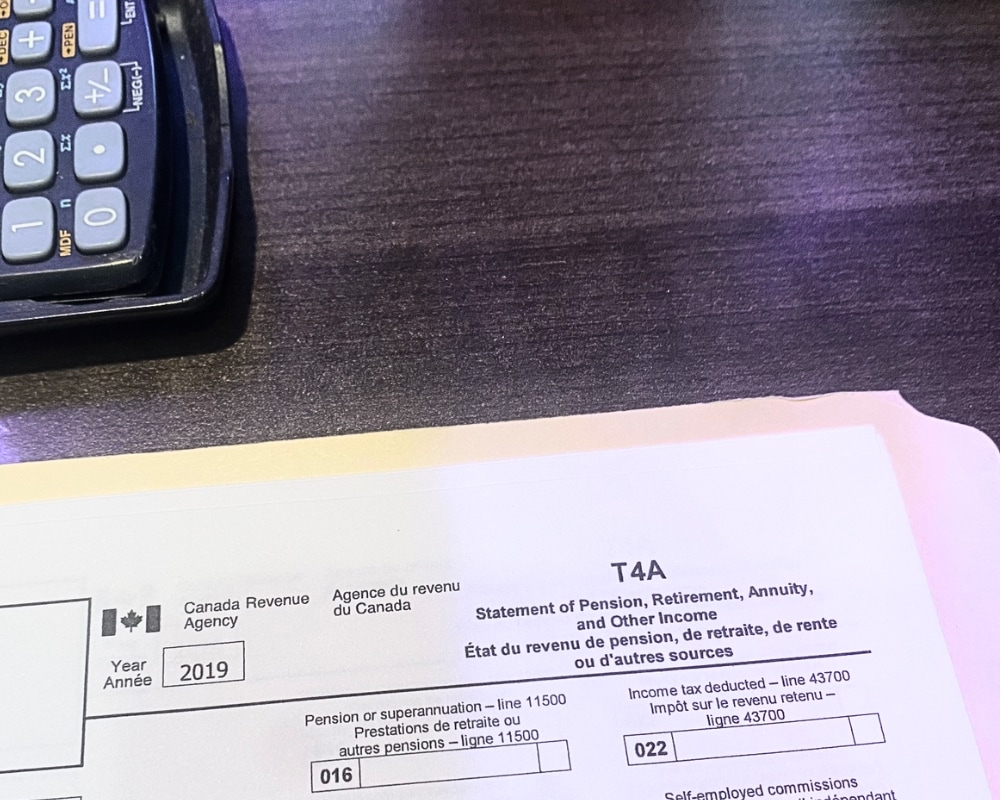 Copy of CRA T4A form on desk with calculator.